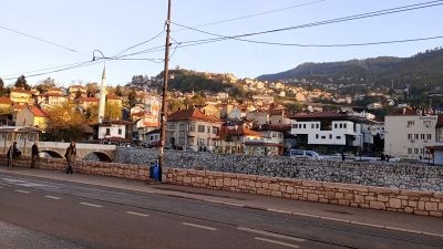 På Miljackas södra strand ungefär i höjd med Nationalbiblioteket.