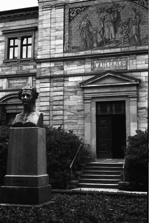 Haus Wahnfried i augusti 2010. Gatufasaden med bysten av Richard Wagners mecenat, kung Ludvig II av Bayern. Över entrén en sgraffitto föreställande Wotan med sina två korpar, till vänster flankerad av ”Tragedin” i form av Wagners favoritsopran Schröder-Devrient, till höger av ”Musiken” i Cosimas gestalt med sonen Siegfried.